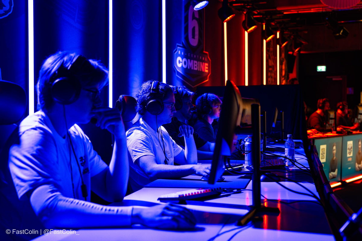 Spieler an Turnierplätzen auf der Bühne unter Blaulicht beim R6 Central Combine 2026
