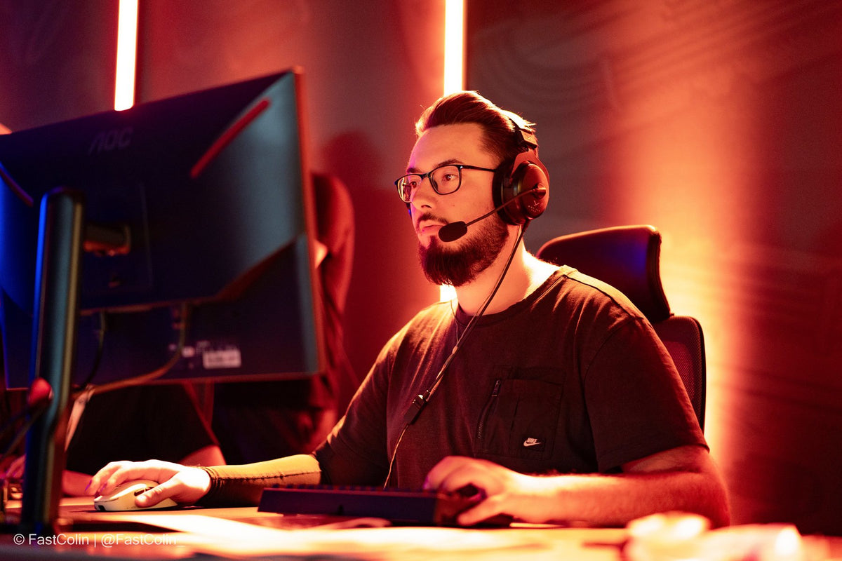 Spieler mit Headset am Gaming-PC während eines Turniermatches